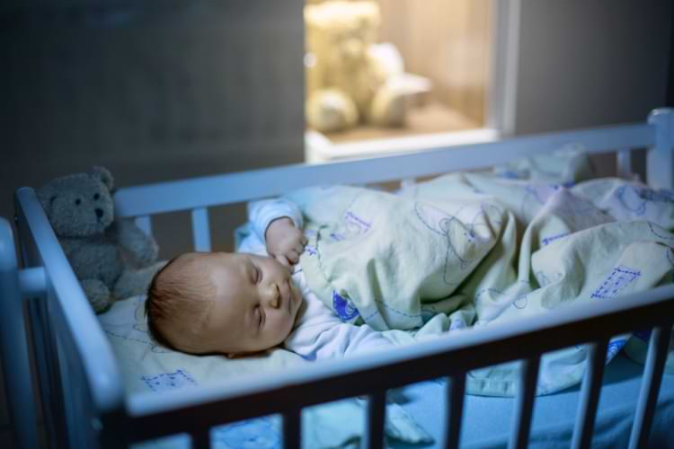 bébé qui dort dans sous la couverture la nuit